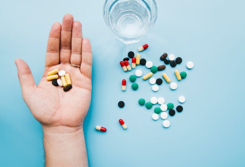 top-view-hand-holding-pills-850x580